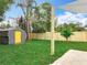 The backyard showcases a new storage shed, lush green lawn, landscaping and a privacy fence at 748 Neuse Ave, Orlando, FL 32804