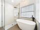 Modern bathroom features a freestanding tub, walk-in shower with rainfall showerhead, and contemporary fixtures at 748 Neuse Ave, Orlando, FL 32804