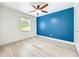 Bright bedroom with a vibrant blue accent wall, ample natural light, and light wood floors at 748 Neuse Ave, Orlando, FL 32804