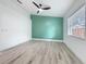 Bright bedroom with fan, light floors, a green accent wall and natural light coming through the window at 748 Neuse Ave, Orlando, FL 32804
