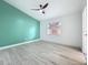 This modern bedroom features a green accent wall, ceiling fan, light-colored wood floors, and a bright window at 748 Neuse Ave, Orlando, FL 32804