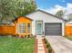 Charming home features a light blue front door, a gray garage door, and a unique wood accent wall at 748 Neuse Ave, Orlando, FL 32804