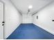 The spacious two car garage has a blue epoxy floor and white walls at 748 Neuse Ave, Orlando, FL 32804