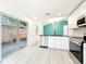 Bright kitchen features white cabinetry, stainless appliances, and an island with a sink, opening to the backyard at 748 Neuse Ave, Orlando, FL 32804