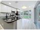 Open kitchen with white cabinets, granite countertops, stainless appliances, and breakfast nook at 748 Neuse Ave, Orlando, FL 32804