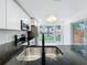 Open kitchen featuring a stainless steel sink, granite countertops, and bay window at 748 Neuse Ave, Orlando, FL 32804