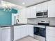 Stylish kitchen features white cabinets, granite countertops, stainless steel appliances, and modern lighting at 748 Neuse Ave, Orlando, FL 32804