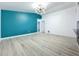 Open living room space showing light gray wood floors and a teal accent wall at 748 Neuse Ave, Orlando, FL 32804