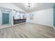 Bright living room with gray flooring, modern lighting, kitchen view and a vibrant teal accent wall at 748 Neuse Ave, Orlando, FL 32804