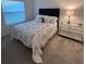 Well-lit bedroom features a plush bed with decorative pillows and glass shelving against neutral walls at 3575 Cochran St, The Villages, FL 32163