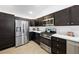 Modern kitchen with dark cabinets, stainless steel appliances, and quartz countertops at 3575 Cochran St, The Villages, FL 32163