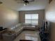 Bright living room featuring tile floors, a ceiling fan, and a comfortable white sectional sofa at 1136 Doncaster Ct, Kissimmee, FL 34758