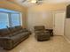 Inviting living room with tile floors, a large window, and a plush recliner sofa at 1136 Doncaster Ct, Kissimmee, FL 34758