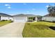 Charming single-story home with well-manicured lawn, inviting curb appeal, and driveway at 3381 Harris Ct, The Villages, FL 32163