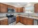A modern kitchen featuring stainless steel appliances and light countertops, complemented by dark cabinets at 3381 Harris Ct, The Villages, FL 32163