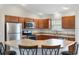 Kitchen with stainless steel appliances, wood cabinets, a corner sink, and a breakfast bar at 3381 Harris Ct, The Villages, FL 32163