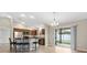 Well-lit kitchen with island and bar seating, stainless steel appliances, and sliding glass doors to a covered patio at 3381 Harris Ct, The Villages, FL 32163
