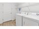 Well-lit laundry room with modern washer and dryer, wire shelving and wood-look floors at 3381 Harris Ct, The Villages, FL 32163