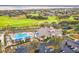 A lovely aerial view of a clubhouse, pool, and meticulously landscaped grounds at 1086 Harmony Ln, Clermont, FL 34711