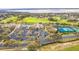 A beautiful aerial view showcasing a community clubhouse with a pool, tennis courts, and ample parking at 1086 Harmony Ln, Clermont, FL 34711