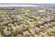 A captivating aerial view of a residential neighborhood with lush greenery and homes near a lake at 1086 Harmony Ln, Clermont, FL 34711
