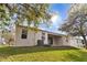 Exterior view of backyard with lawn, trees, and a covered patio at 1086 Harmony Ln, Clermont, FL 34711