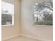 Bright bedroom featuring tile floors, two windows, and neutral walls at 1086 Harmony Ln, Clermont, FL 34711
