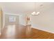 Open living room with wood floors, modern chandelier, and view into kitchen at 1086 Harmony Ln, Clermont, FL 34711