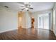 Spacious living room with a ceiling fan and wood floors, next to sliding glass doors at 1086 Harmony Ln, Clermont, FL 34711