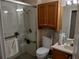 Bathroom featuring glass shower, a toilet, vanity sink, and wooden cabinets with a towel rack at 30126 Sandbunker Ln, Sorrento, FL 32776