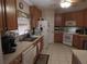 A functional kitchen featuring white appliances, wood cabinets, and tile floors at 30126 Sandbunker Ln, Sorrento, FL 32776