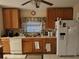 A functional kitchen featuring white appliances, wood cabinets, and tile floors at 30126 Sandbunker Ln, Sorrento, FL 32776