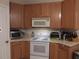 Traditional kitchen featuring wooden cabinets, white appliances, and ample countertop space at 30126 Sandbunker Ln, Sorrento, FL 32776