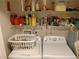 Functional laundry room with washer, dryer, and storage shelves at 30126 Sandbunker Ln, Sorrento, FL 32776