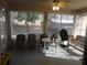 Enclosed back porch patio with seating, providing a comfortable outdoor living space at 30126 Sandbunker Ln, Sorrento, FL 32776