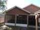Rear patio with screened enclosure and access to back yard at 30126 Sandbunker Ln, Sorrento, FL 32776