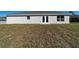 Home's exterior shows a simple backyard with a new lawn and door access at 20184 Sw 57 St, Dunnellon, FL 34431