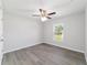 Bright bedroom features hardwood floors, a ceiling fan, and a sun-filled window overlooking the front yard at 20184 Sw 57 St, Dunnellon, FL 34431
