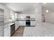 Bright kitchen features stainless appliances, white cabinets, and a granite-topped island at 20184 Sw 57 St, Dunnellon, FL 34431