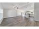 Spacious living area with grey wood-look floors, a ceiling fan, and seamless flow into a modern kitchen at 20184 Sw 57 St, Dunnellon, FL 34431