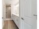 Main bathroom featuring double sinks, a walk-in shower with tile surround, and wood-look flooring at 20184 Sw 57 St, Dunnellon, FL 34431