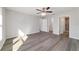 Spacious main bedroom with gray wood floors, a ceiling fan, and two entryways for easy access at 20184 Sw 57 St, Dunnellon, FL 34431