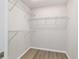 Walk-in closet featuring built in metal shelving and wood flooring at 20184 Sw 57 St, Dunnellon, FL 34431