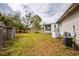 Large backyard with grass, trees, sheds, and a screen room attached to house at 2486 Daytona Park Rd, Deland, FL 32724