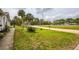 Home's front yard featuring grass, plants, palm trees, and a view of the street at 2486 Daytona Park Rd, Deland, FL 32724