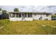 Rear exterior view featuring a screened porch, siding, and a spacious lawn needing TLC at 2486 Daytona Park Rd, Deland, FL 32724