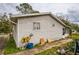 Exterior side view with siding, a window, and mature landscaping ready for upgrading at 2486 Daytona Park Rd, Deland, FL 32724