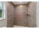 Modern bathroom features a tiled shower with gray stone-look tiles and sleek fixtures at 15673 Sw 37 Cir, Ocala, FL 34482