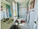 Bright bathroom with a large vanity, tub with shower, and blue accent wall at 16832 Bolsena Dr, Bella Collina, FL 34756