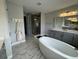 Modern bathroom featuring a soaking tub, glass shower, and double sink vanity with sleek finishes at 16832 Bolsena Dr, Bella Collina, FL 34756